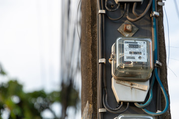 August 9th 2019 Udon Thani Thailand: Old electricity meter on electricity post in outdoor with .vine nature,The meter is a unit of power reading for Provincial Electricity Authority