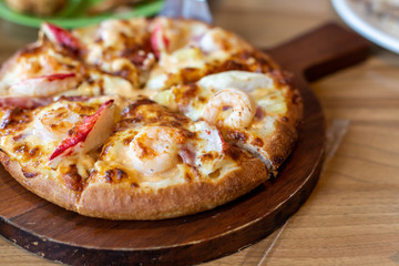 Seafood Italian Pizza slice on wood dish