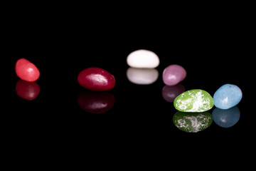 Group of six whole jelly bean candy isolated on black glass