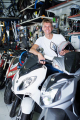 Fototapeta na wymiar Young smiling motorcyclist sitting on the motorbike