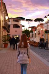 Teen girl walking and taking a picture in an old city