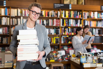 guy with stack of books in hands