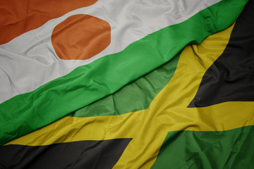 waving colorful flag of jamaica and national flag of niger.