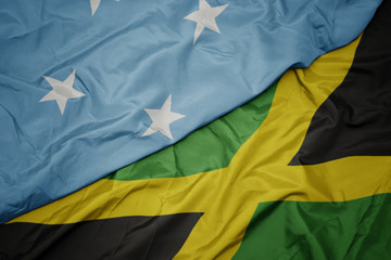 waving colorful flag of jamaica and national flag of Federated States of Micronesia .