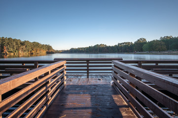 Scenic view of wooden bridge over lake rim at sunrise