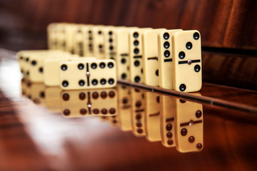 The concept of diversity - figures from the game of dominoes on a wooden background, some figures lie the other neatly stand side by side