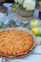 Homemade apple pie on the tablecloth decorated with green leaves