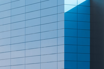 Geometric colored building facade elements with planes, lines and corners with light flare and reflections for an abstract background and texture of white, blue, gray colors. Place for text