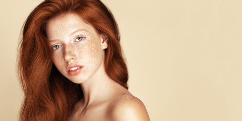 Freckles young Beauty girl portrait. Attractive model with beautiful natural ginger red hair