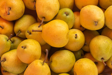 Yellow ripe pears lined up for sale in a supermarket