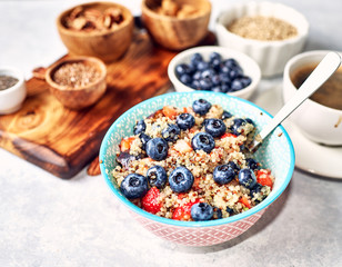 healthy breakfast, quinoa porridge with blueberries, nuts, seeds and superfoods
