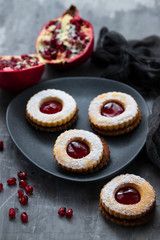 cookies with jam and pomegranate on ceramic background
