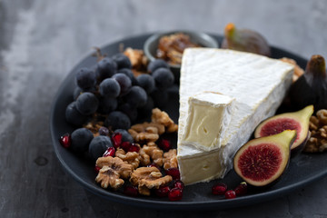 figs with cheese and pomegranate on ceramic background