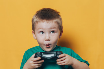 small boy with joystick on yellow background © Anastassiya 