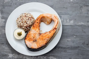 fried salmon with rice and sauce on white dish