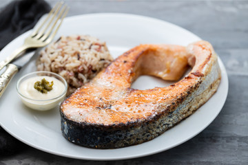 fried salmon with rice and sauce on white dish