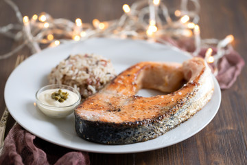 fried salmon with rice and sauce on white dish