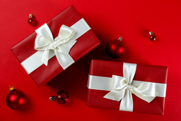 Bunch of christmas presents wrapped in red and white paper tied with shiny silk bow. Multiple new years gifts in red and white wrapping. Top view, close up, copy space, background, flat lay.