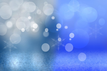 Abstract blurred festive winter christmas background with shiny blue and white bokeh lighted snow landscape with stars and a blue sky.
