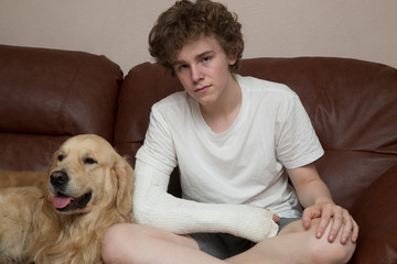 A broken arm. Fracture of the forearm at the teenager. Arm in plaster.The dog and the teenager.