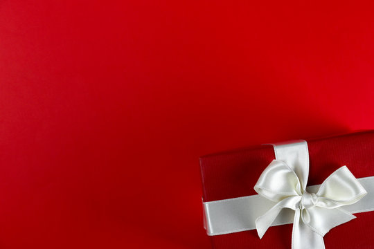 Bunch of christmas presents wrapped in red and white paper tied with shiny silk bow. Multiple new years gifts in red and white wrapping. Top view, close up, copy space, background, flat lay.