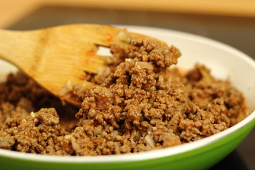 Pan frying ground beef with chilli sauce. Mixing.