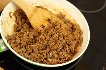 Pan frying ground beef with chilli sauce. Mixing.
