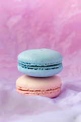 Tasty french macaroons with strawberries and dor blue cheese on a pastel pinkish-purple background