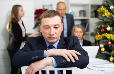 Business team tensely solving problems in office with offended man foreground