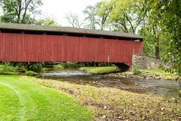 Red covered bridge over a small creek in rural Pennsylvania