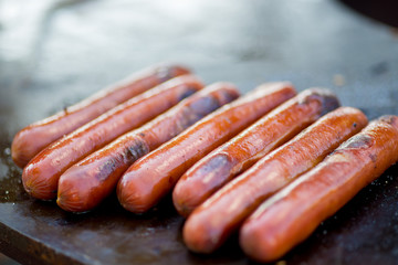 sausages are grilled over an open fire