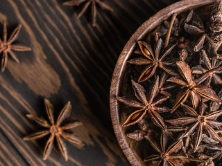 anise stars and cinnamon sticks tied up with rope on wooden brown background