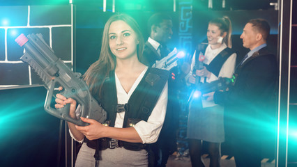 Fototapeta na wymiar Woman holding laser gun and playing laser tag