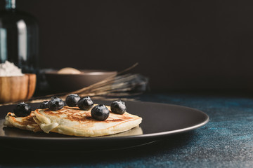 Plate of pancakes with blueberries, vase and a bowl of flour and copy space design