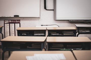 Contemporary student desks placed into rows within brightly lit room filled with studying materials