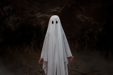 Kid in costume of white ghost . Theme of Halloween and horror