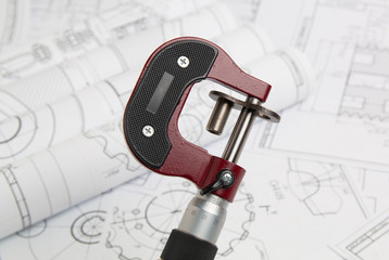 measuring a part with a micrometer in the background