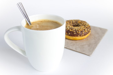 A large white cappuccino Cup and a frosting doughnut