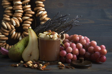 Caramel dessert with pear, nuts and dried fruits on a gray wooden background. Near lavender, pears. Bagels in the background