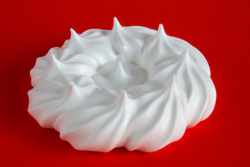 white meringue on red background close up