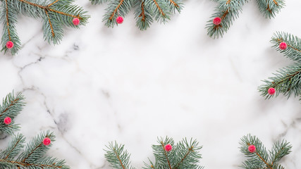 Christmas or New Year frame. Xmas greeting card. Christmas gifts and fir tree branches on white marble background. Flat lay, top view, copy space