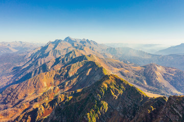 Obraz premium Large rocky mountain range with peaks and troughs, aerial view on a clear sunny day with good weather.