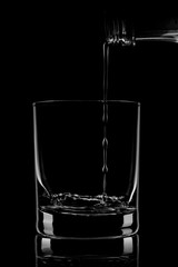 water is poured into a glass, dark background