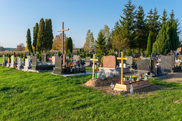 Cemetery with visible tombstones and crosses on a sunny day.