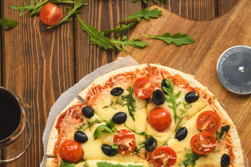 Pizza with wine tomatoes cheese and arugula