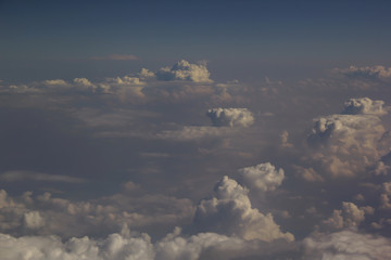 Top view of clouds from an airplane window on a sunny day