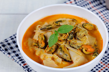 Coconut Milk Curry with bamboo shoot and green mussel in bowl on wood table