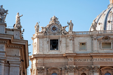 The top-left corner of the Basilica of St. Peter in the Vatican with the clock and the belfry. The...