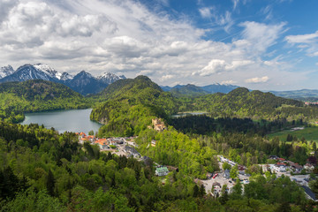 Fototapeta na wymiar View over Hohenschwangau castle in Germany from east with lake Alpsee and alps in background.