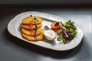 Potato pancakes with red caviar and vegetables
